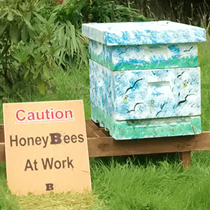 Green People - Decorated Beehive and Honeybees at work sign - Plan Bee Ltd